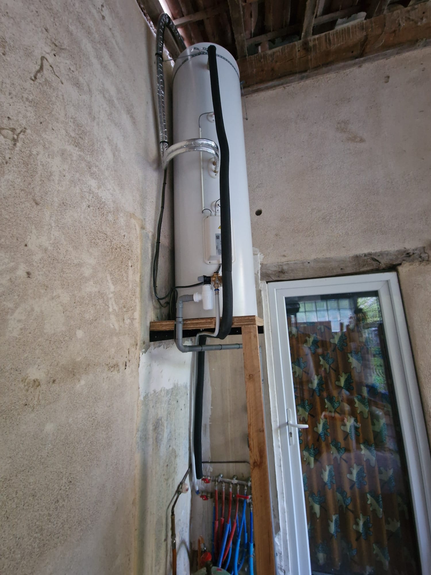 Chauffe-eau thermodynamique installé contre un mur